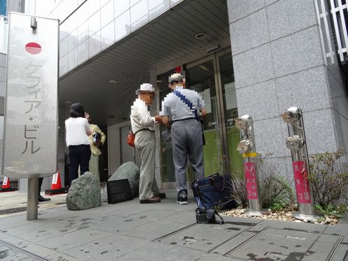 ケフィア事業振興会の「公示書」をみる高齢者